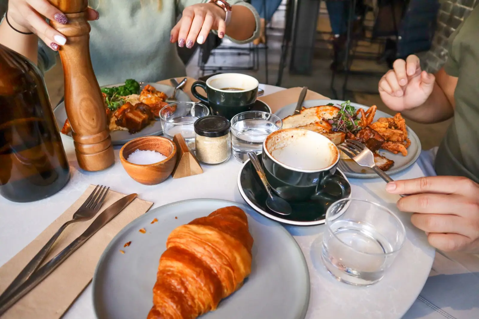 A casual weekend brunch table with pastries and coffee in natural daylight.