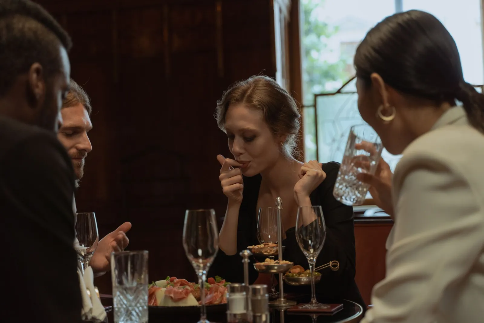 A group of friends sharing a relaxed dinner with drinks.