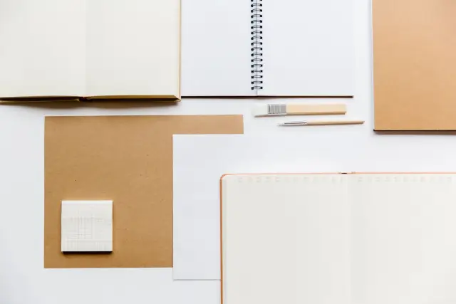 Open notebooks and pens arranged on a desk, ready for planning.