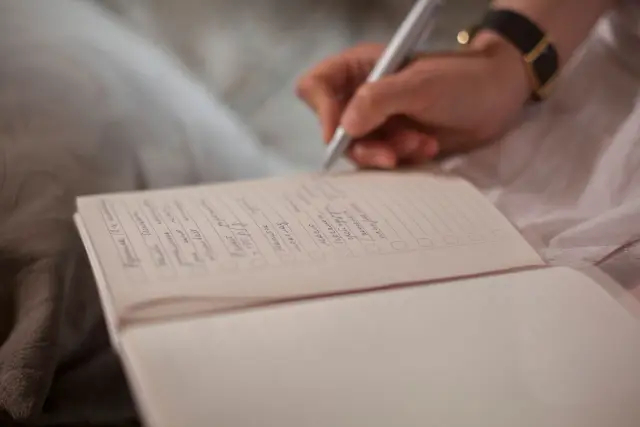 A hand writing in a journal.