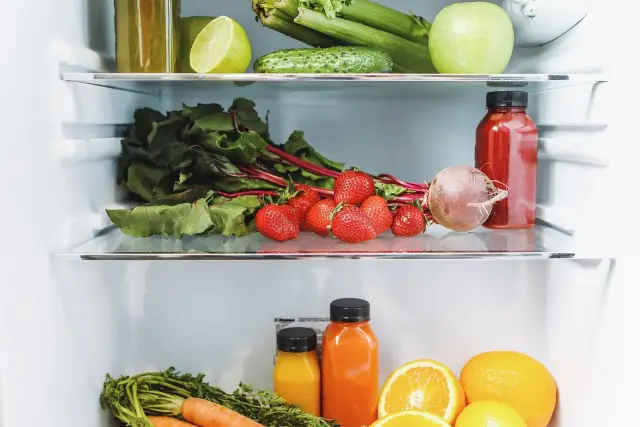 A woman looking into an open refrigerator.