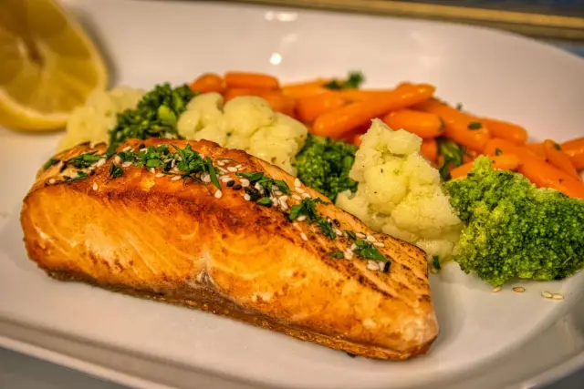 Grilled salmon with mixed vegetables on a plate.