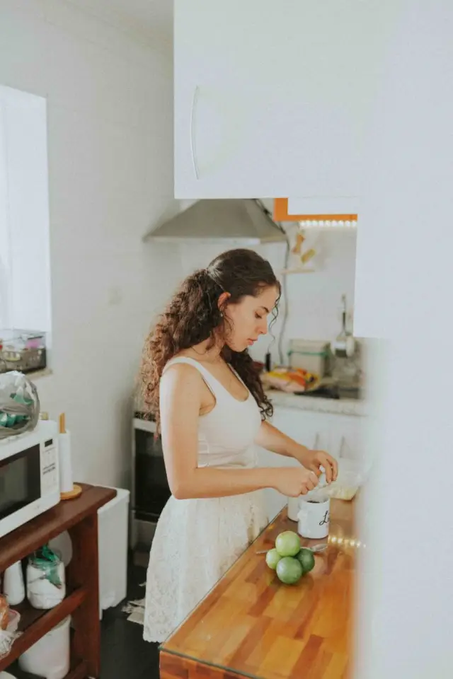 A person preparing fresh ingredients on a bright kitchen counter in daylight.