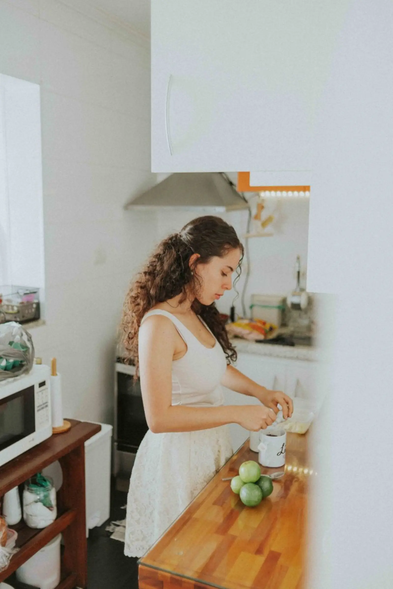 A person preparing fresh ingredients on a bright kitchen counter in daylight.