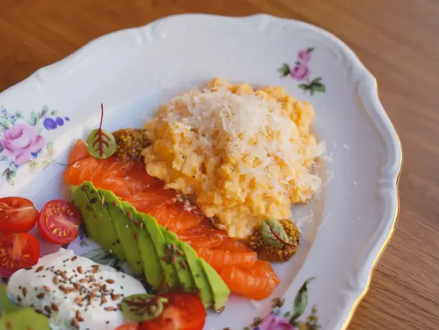 A plate of scrambled eggs, smoked salmon, and avocado, a protein-forward meal for maintenance.