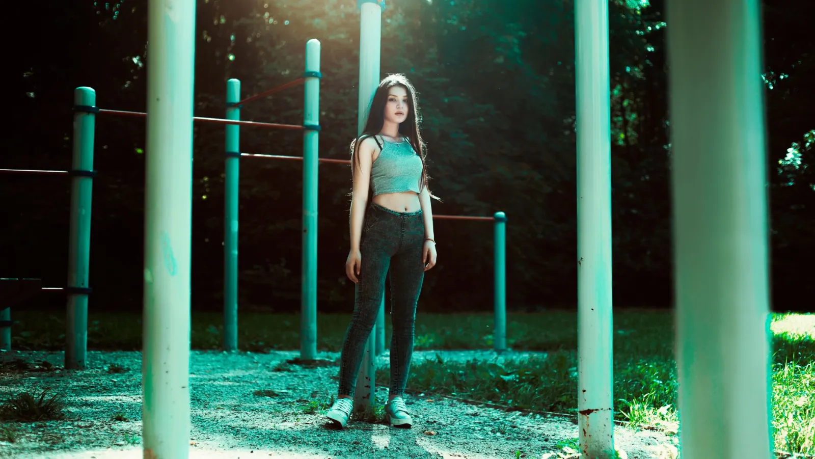 A woman standing confidently in a sunlit outdoor park.
