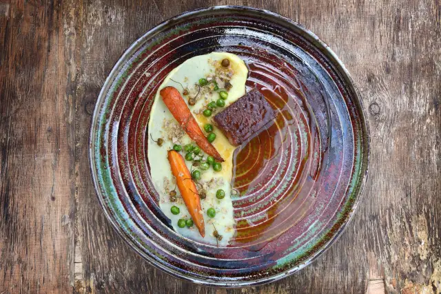 A single plated dish with a modest portion of vegetables on a rustic wooden table.