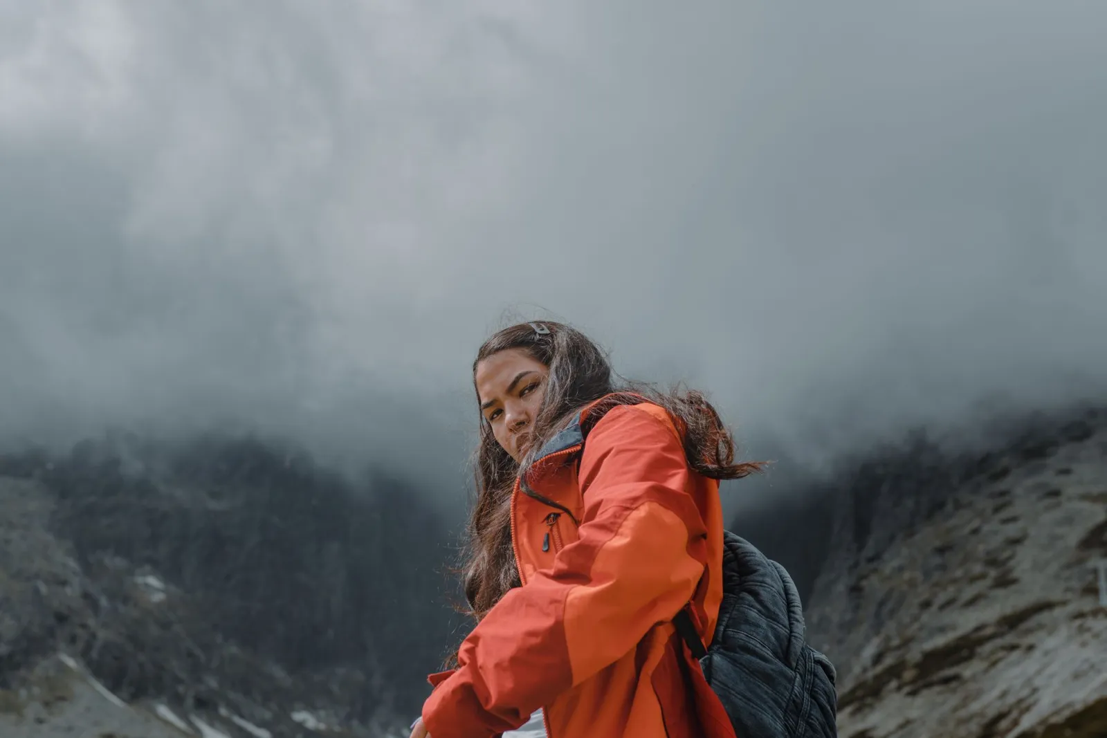 A woman hiking on a foggy mountain day.